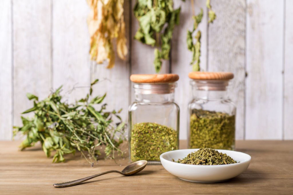 herbal tea and dried herbs in jars with spoon