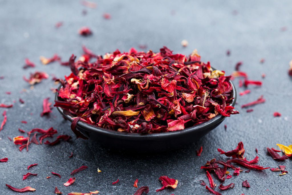 hibiscus tea in black bowl. slate background. close up.